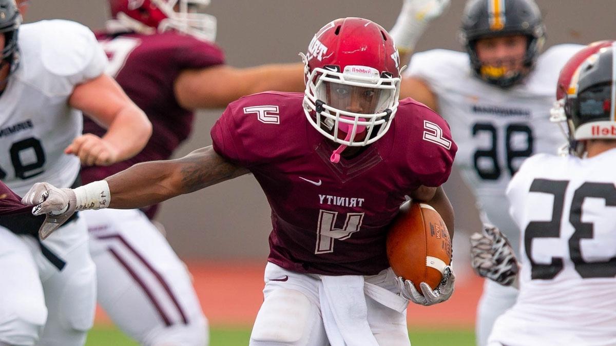 football player, number 4, stiff arms opponent while carrying ball